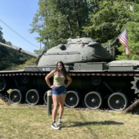 PA standing in front of a military tank