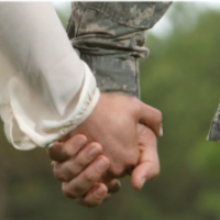 Photo of two hands holding--one of a woman's hand, the other hand that of a service member in uniform